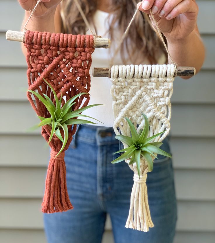 a woman is holding two plants and weaving them