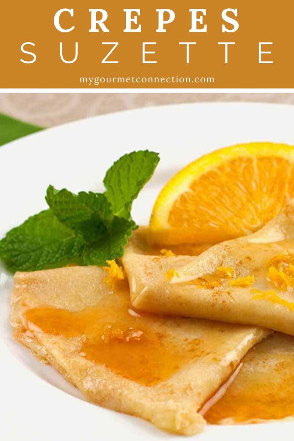 crepes with orange sauce on a white plate and garnished with mint