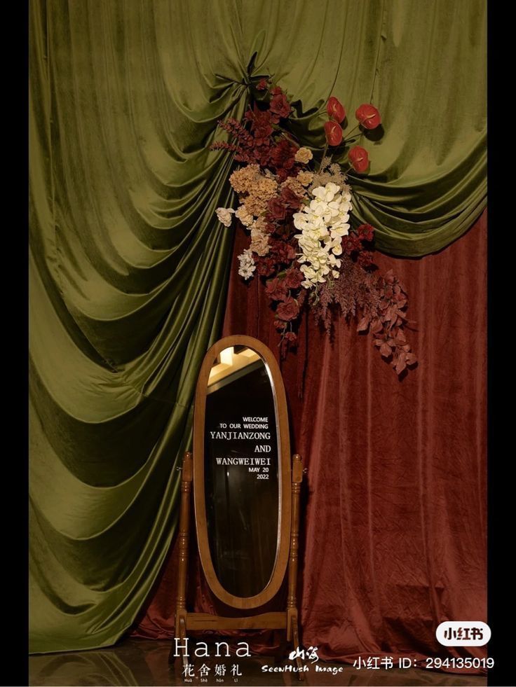 a mirror sitting on top of a wooden stand in front of a curtained wall