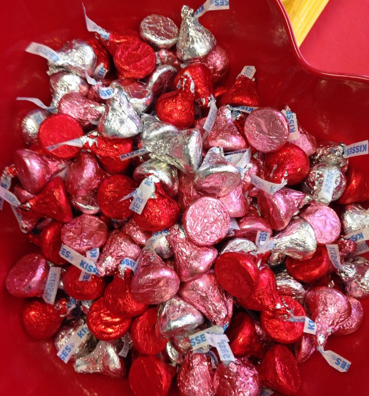 a red bowl filled with lots of heart shaped candy