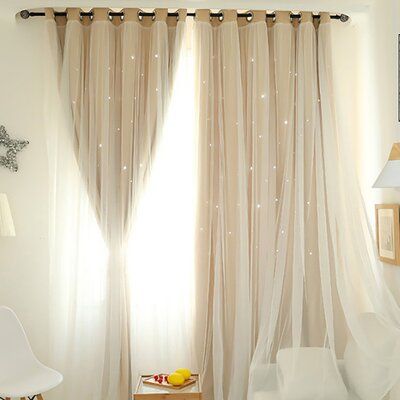 a white chair sitting in front of a window covered in sheer curtains and star decorations