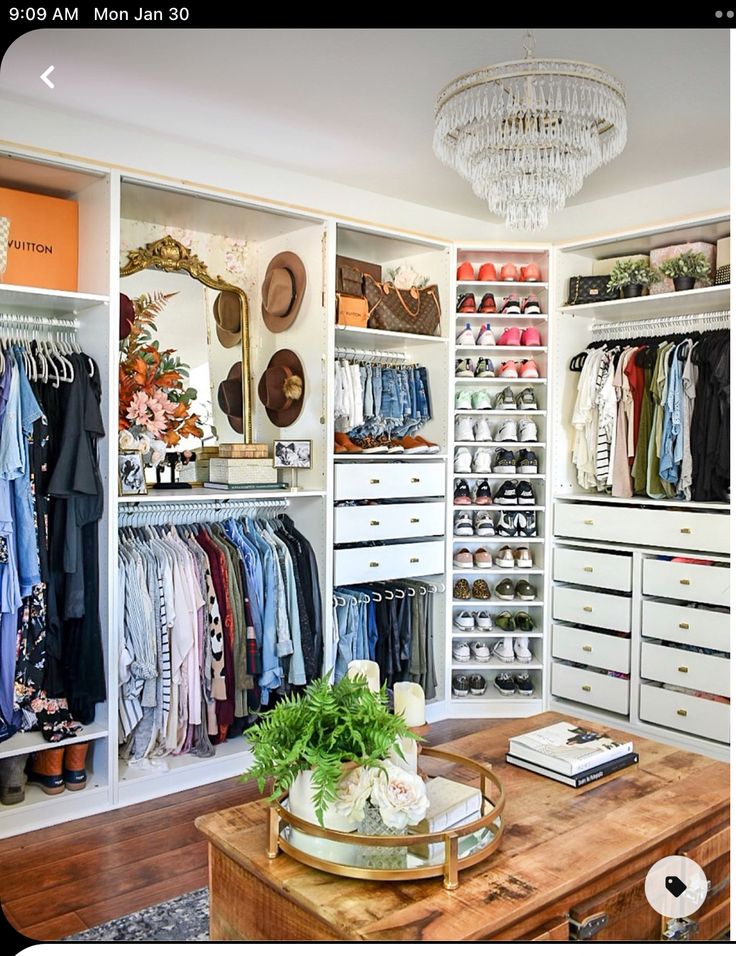 an organized closet with clothes, shoes and other items on shelves next to a coffee table