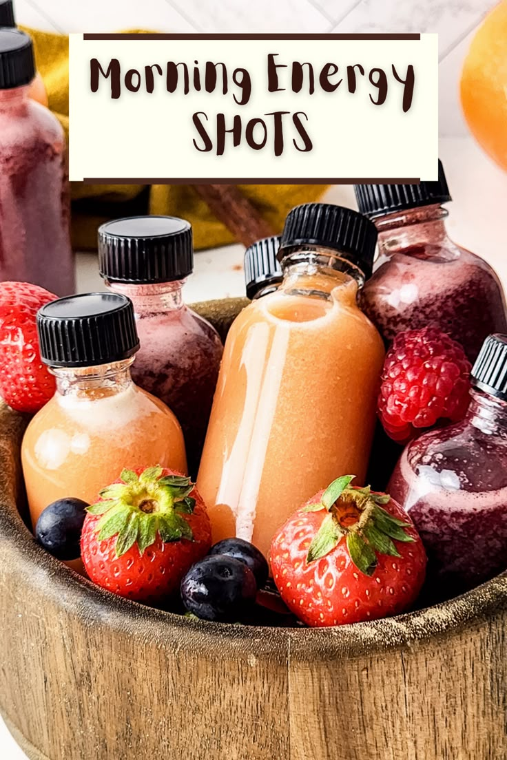 a wooden bowl filled with different types of smoothies and juices next to a sign that says morning energy shots