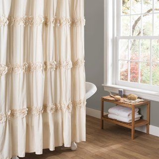 a shower curtain with ruffles on it in front of a bathtub and window