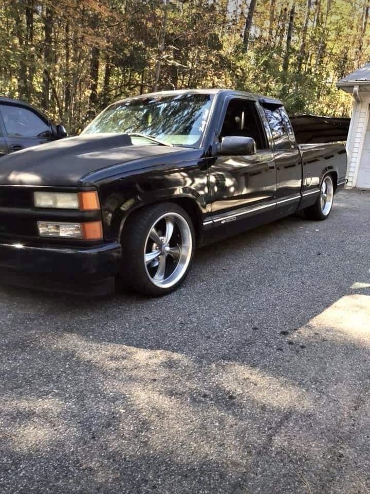 a black pickup truck parked in front of a house