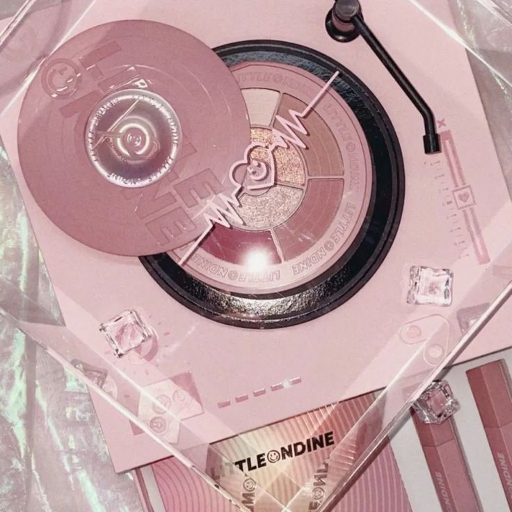 a close up of a pink clock in a plastic case on top of a table