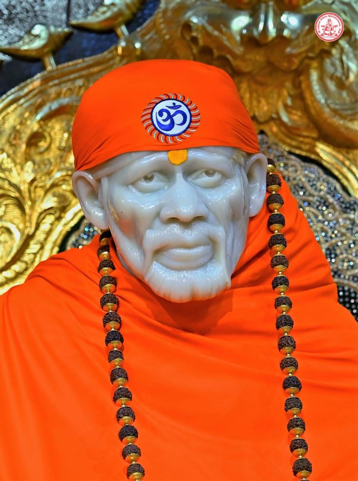 a statue of a man wearing an orange outfit with beads around his neck and head