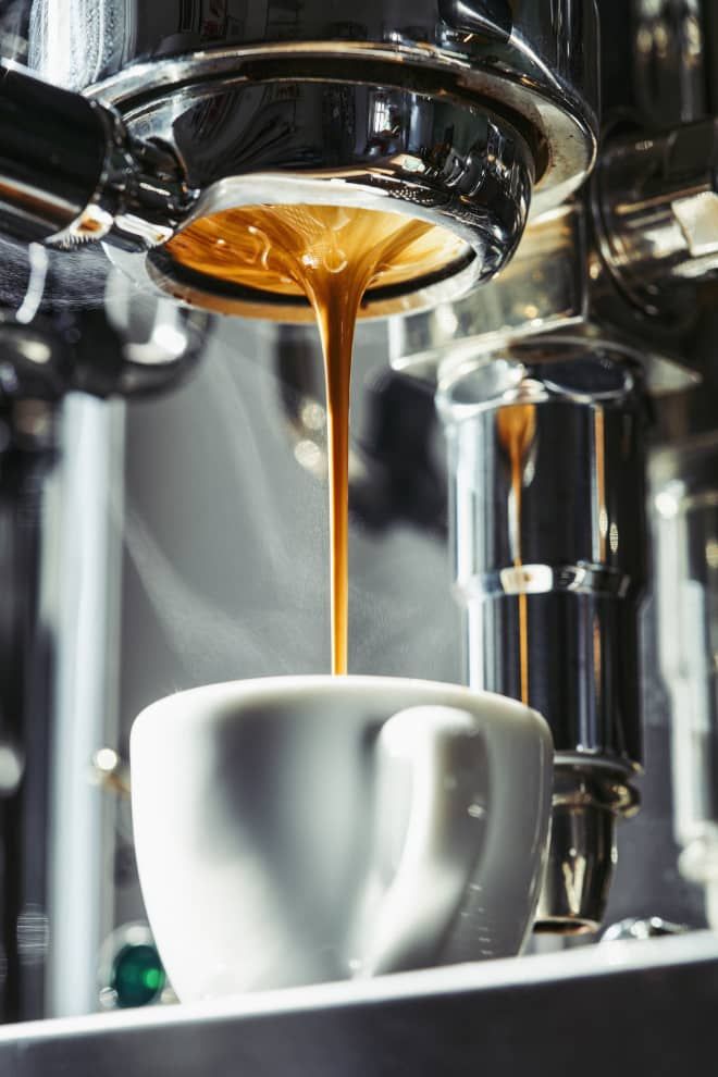 coffee being poured into a white cup