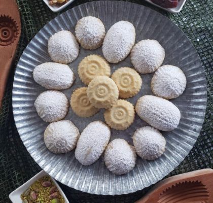 several different types of pastries on a plate next to bowls of fruit and desserts