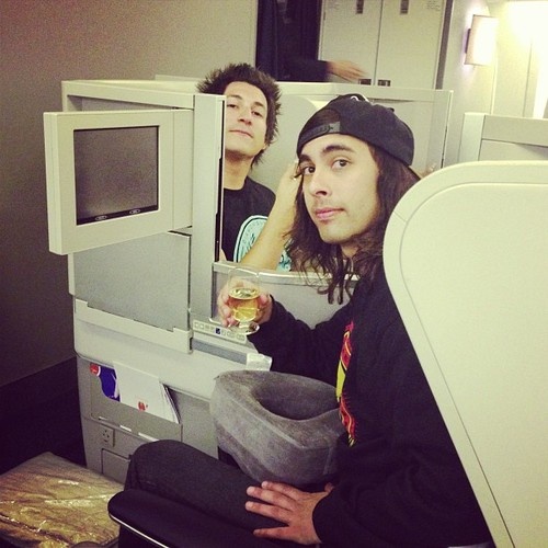 two young men are sitting in front of a microwave and looking at their own reflection