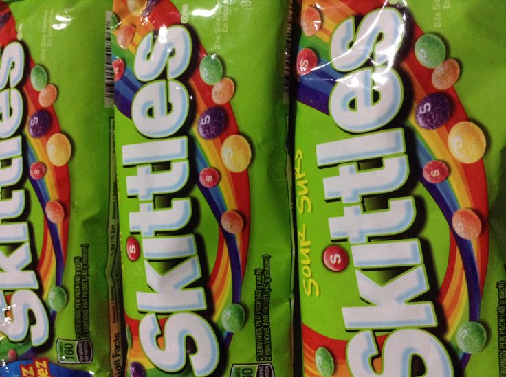 three bags of skittles are on display