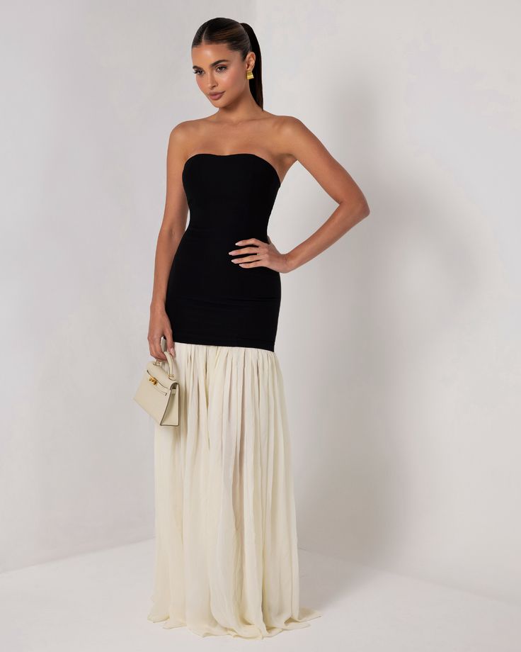 Introducing the Black Strapless Cream Chiffon Maxi Dress, a graceful blend of modern simplicity and timeless elegance. This stunning dress features a sleek, strapless black bodice that accentuates the shoulders and waist, providing a smooth and flattering silhouette. The bodice seamlessly transitions into a flowing cream chiffon maxi skirt that cascades to the floor, creating a soft, ethereal movement with every step. The contrast between the bold black top and the delicate cream skirt adds a sophisticated touch, making this dress perfect to dress down for the day or to dress up for formal events, galas, or evening soirées. Embrace effortless style with this versatile and elegant piece. Elegant Strapless Bandeau Dress For Gala, Elegant Bandeau Strapless Dress For Gala, Elegant Strapless Bandeau Dress With Pleated Bodice, Strapless Pleated Bodice Maxi Dress For Gala, Elegant Bandeau Strapless Dress With Boned Bodice, Elegant Strapless Bandeau Dress With Boned Bodice, Strapless Maxi Dress With Lined Bodice For Gala, Strapless Maxi Dress With Boned Bodice For Summer, Chic Strapless Maxi Dress For Formal Occasions