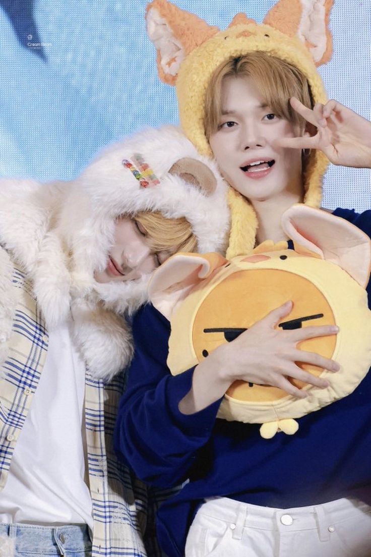 two young people wearing animal costumes posing for a photo with one person holding a stuffed animal