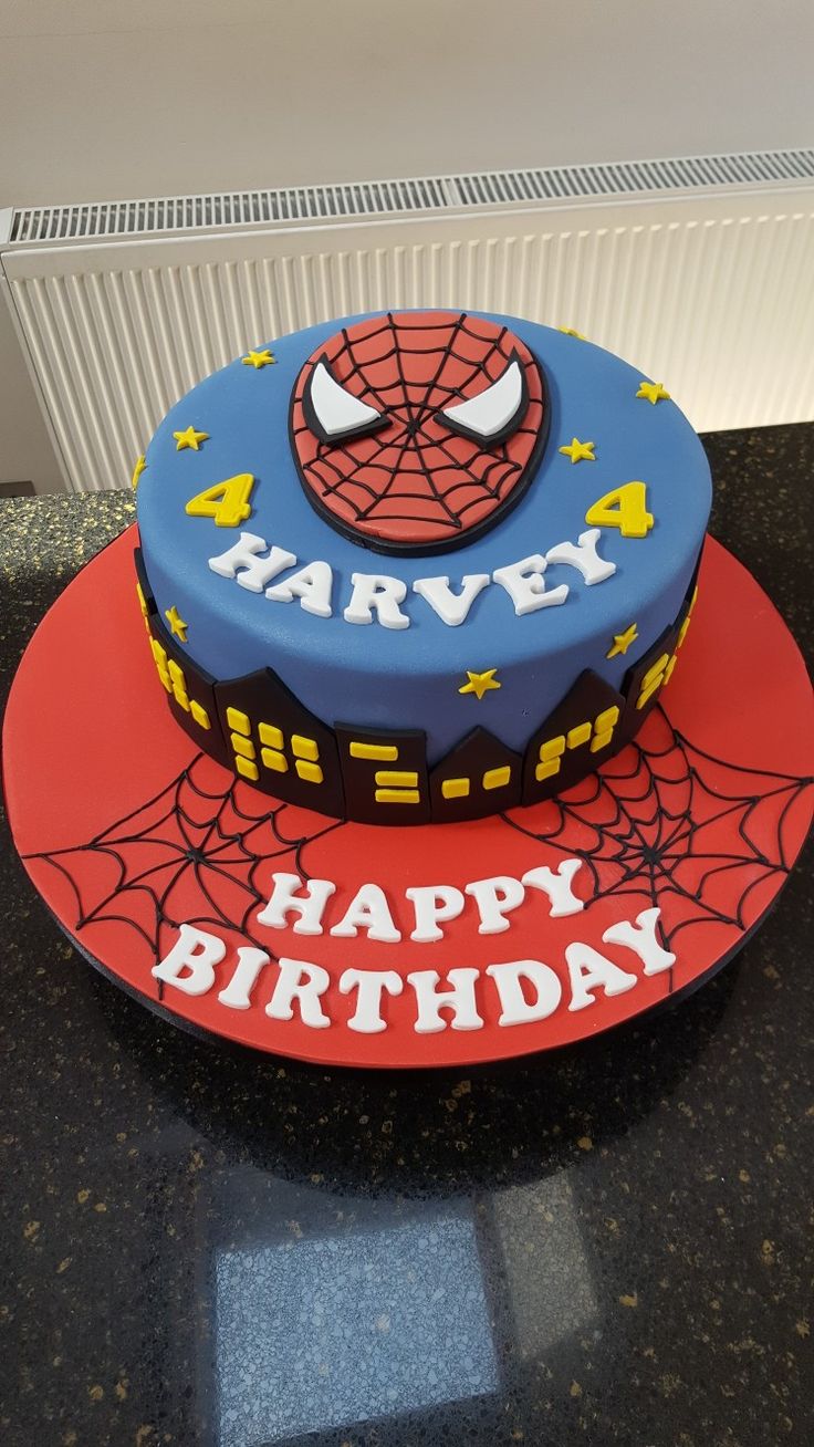 a spiderman birthday cake on top of a red and blue plate with the name harvey written on it