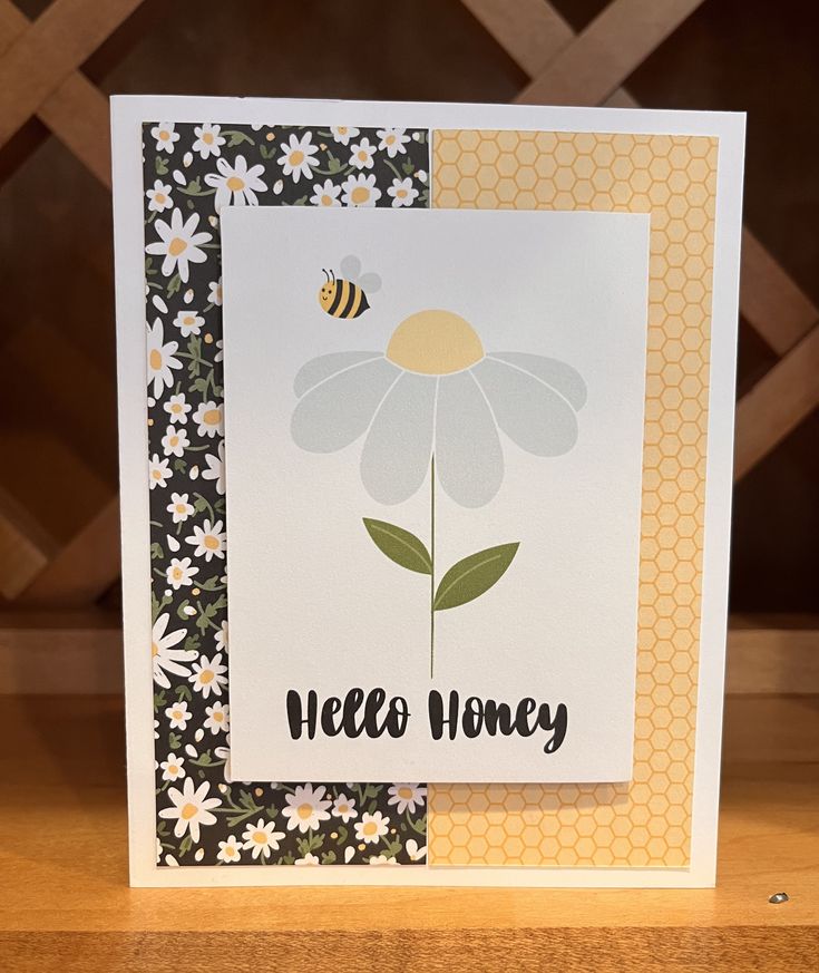 a close up of a card with a flower and a bee on the front side