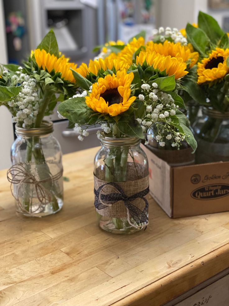 sunflowers and baby's breath in mason jars on a counter