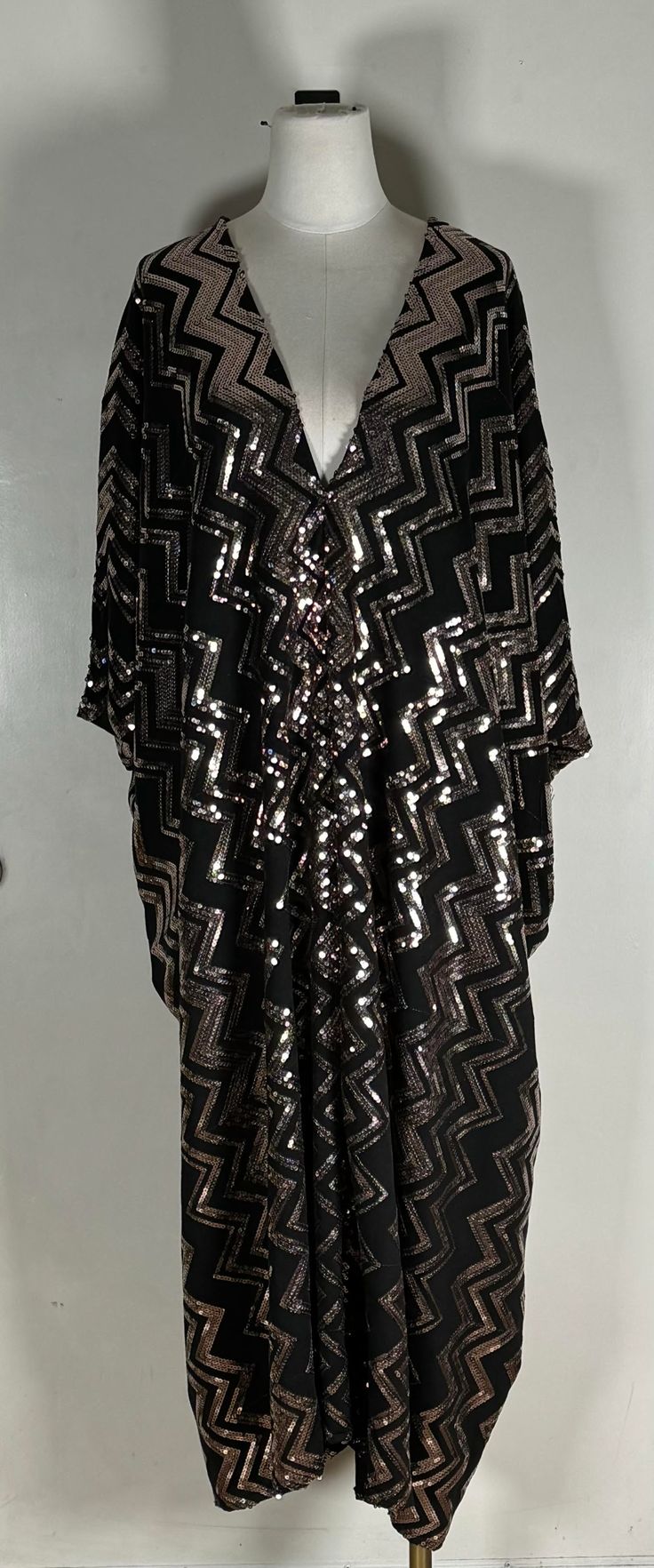 Unleash your inner sparkle with the Dionne Sequin Caftan. This stunning caftan features a shining copper zigzag design that will make you stand out in any crowd. Its glamorous appearance, hides that she is as comfortable as your favorite tshirt, with an unlined construction that allows for effortless movement. Dare to be bold and embrace the GLAMour of this eye-catching, sequin caftan. Our caftans are a voluminous one-size fits all garment, approximately 50" in length. The intention of this shap Gold V-neck Kaftan For Party, Bohemian Sequin Kaftan For Parties, Festive Long Sleeve Tunic For Party, Gold Bohemian Kaftan For Party, Black Sequined Kaftan For Party, Chic Party Tunic Kaftan, Sequin Caftan, Zigzag Design, Friends Fashion