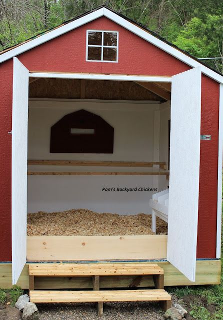 a red and white shed with a bench in front of it that is built into the ground