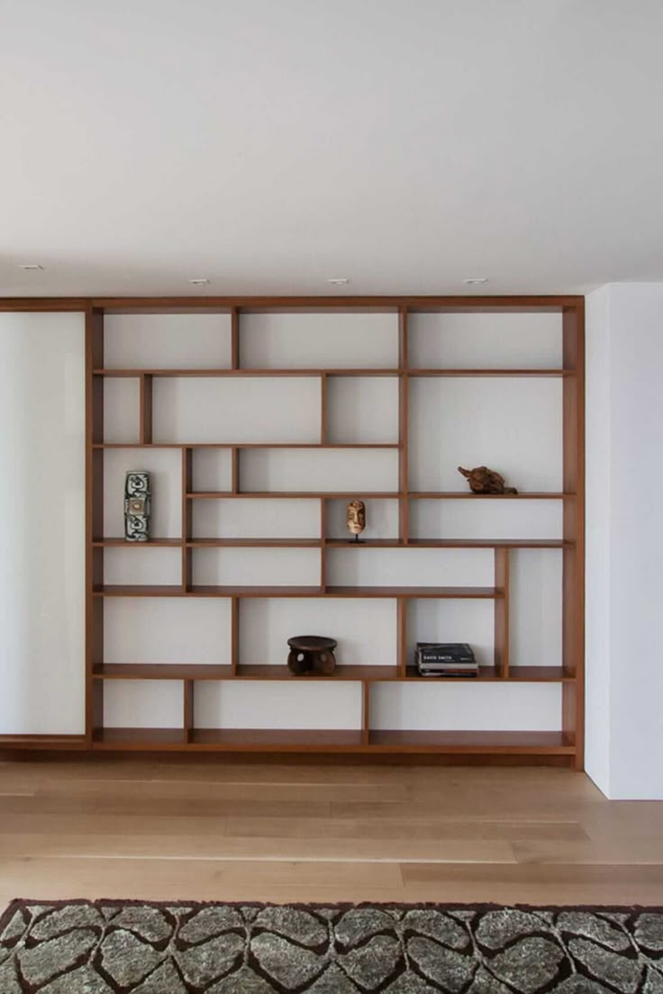 a living room filled with furniture and a large book shelf on top of a hard wood floor