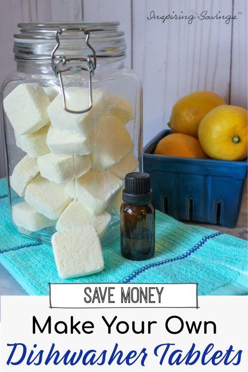 a jar filled with marshmallows sitting on top of a blue towel next to lemons