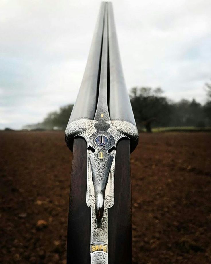 a close up view of a bike tire on a dirt field with trees in the background