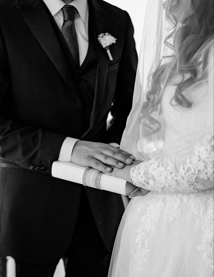 a bride and groom holding hands during their wedding ceremony