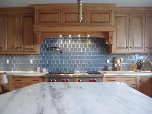 a kitchen with marble counter tops and wooden cabinets