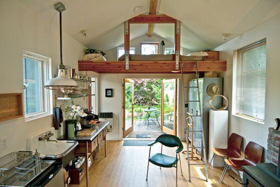 a loft bed is in the middle of an open kitchen and dining area with lots of natural light