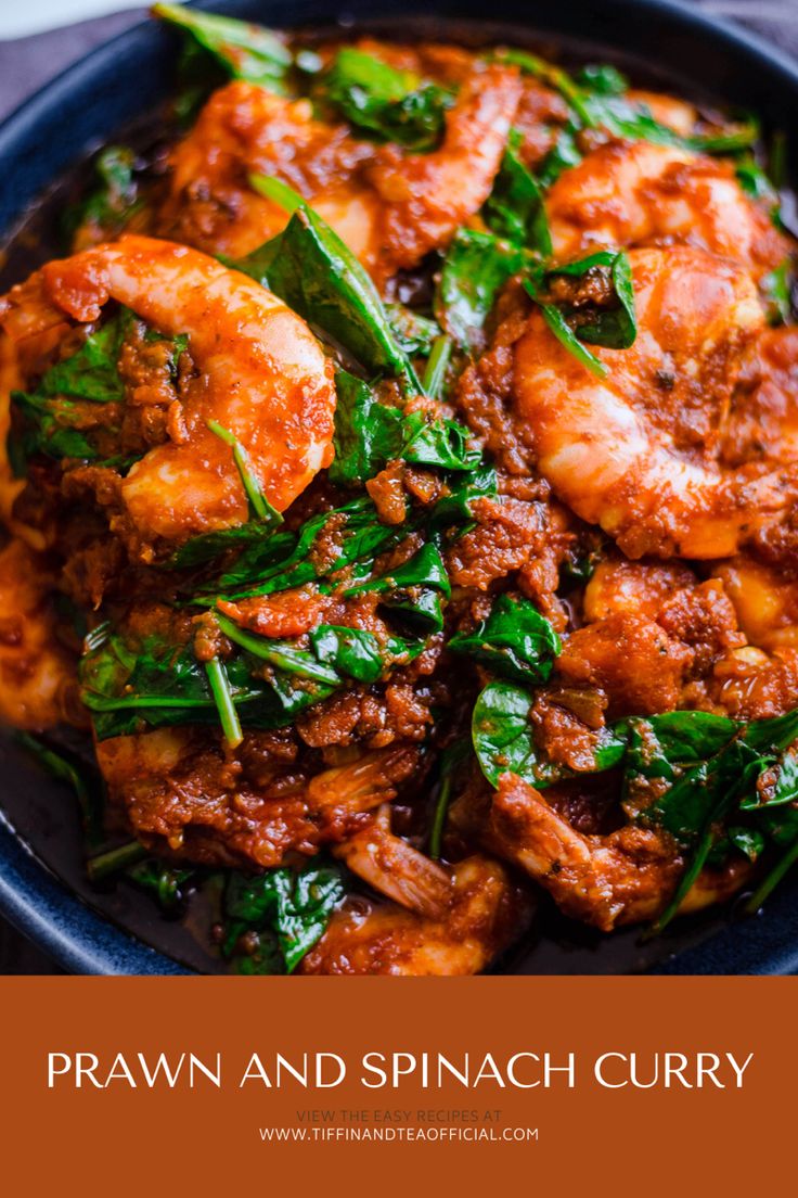 a blue bowl filled with shrimp and spinach curry