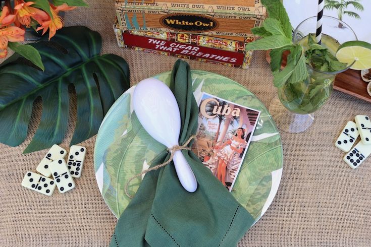 the table is set with green and white plates, napkins, and other decorative items