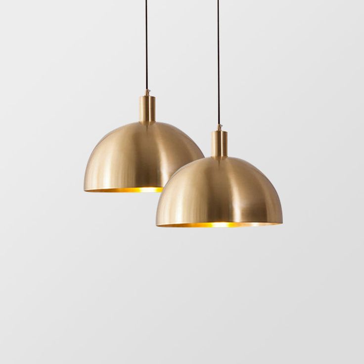 two brass pendant lights hanging from the ceiling