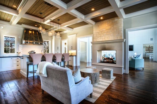 a living room filled with furniture and a fire place in the middle of a kitchen