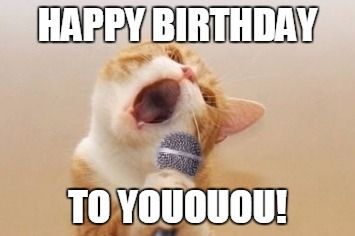 an orange and white cat holding a microphone in it's mouth with the caption happy birthday to you