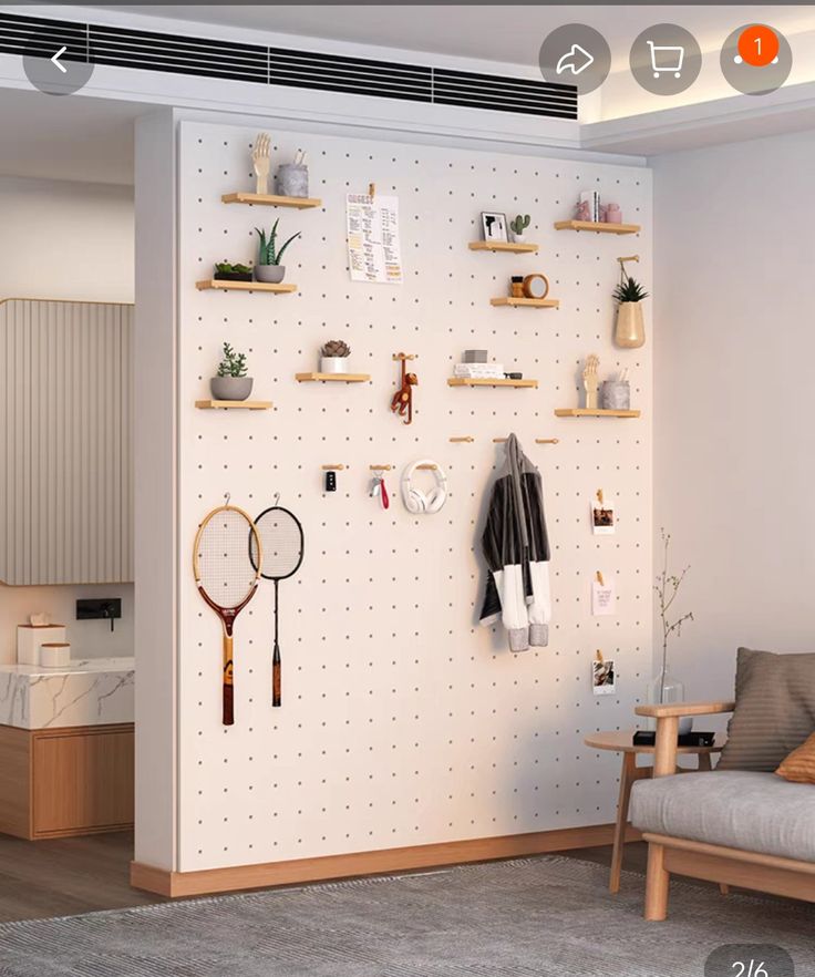 a living room with a couch, chair and wall mounted rack holding tennis racquets