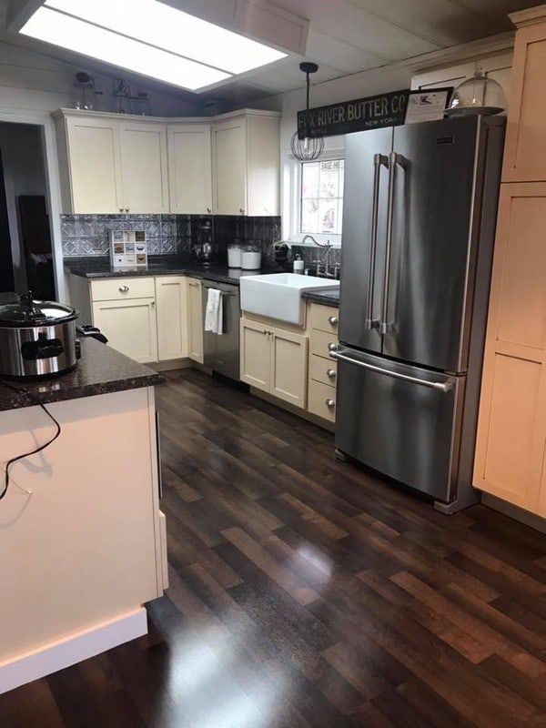 an empty kitchen with stainless steel appliances and wood flooring is pictured in this image