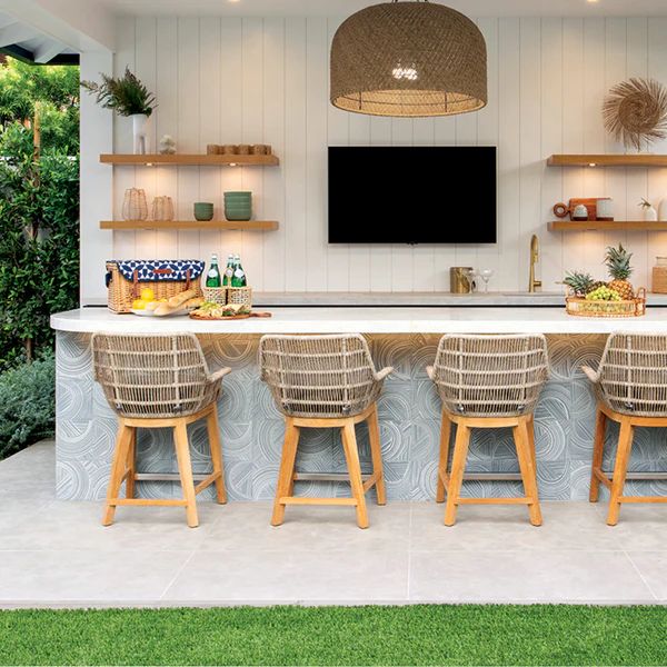 an outdoor bar with stools and shelves on the wall, next to a television