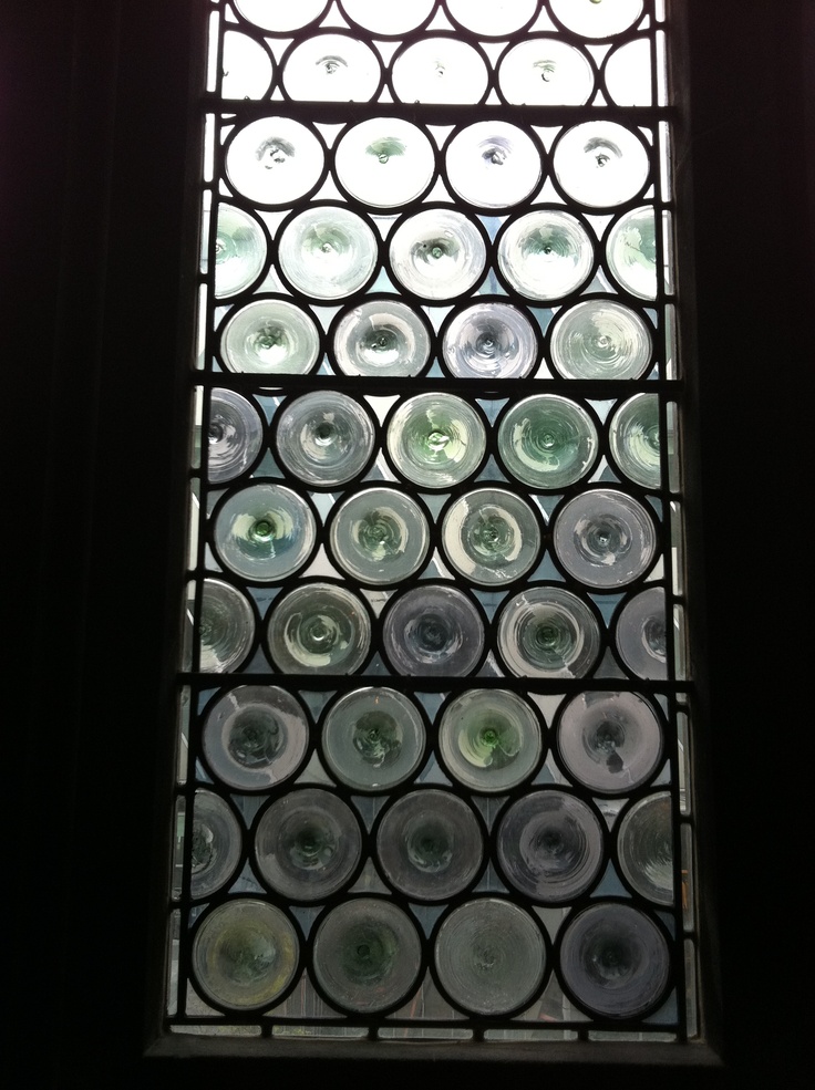 a large window with circular glass in it's center and the light coming through