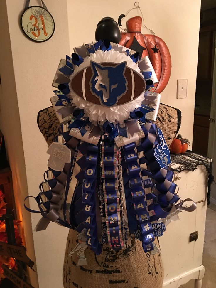 a football trophy with blue and white ribbons on it