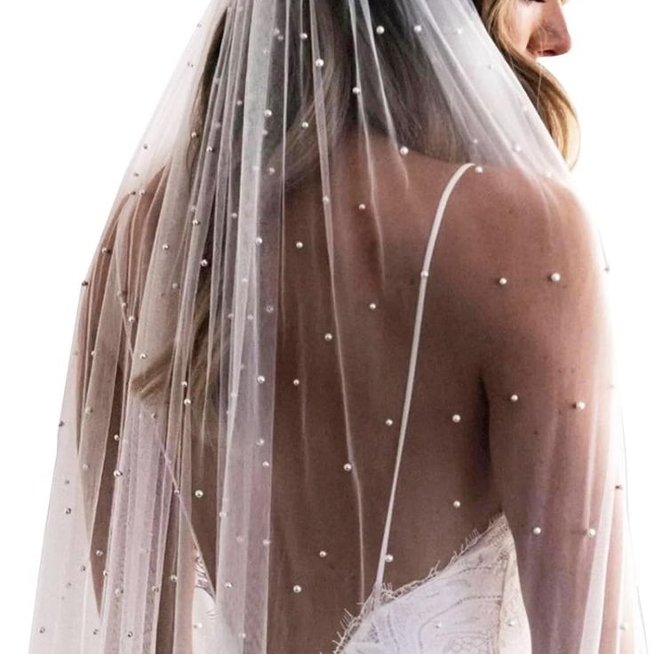 a woman wearing a wedding veil with pearls on the back of her head and shoulders