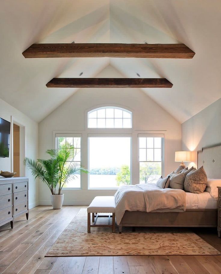 a large bedroom with wooden floors and white walls