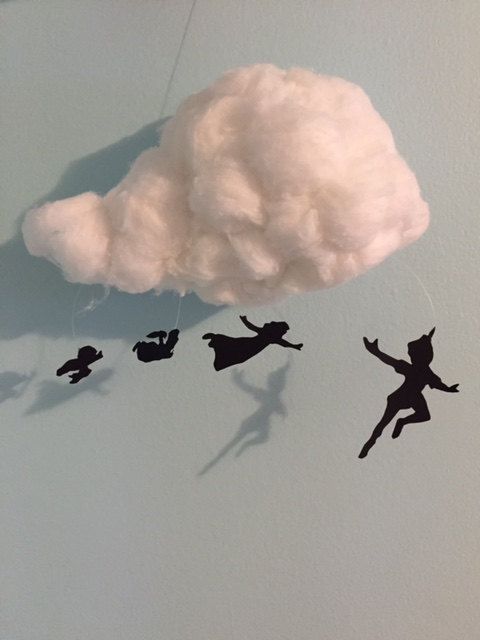 the silhouettes of people are flying through the air in front of a cotton cloud