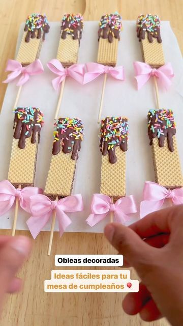 someone is decorating pops with chocolate and sprinkles on sticks for dessert