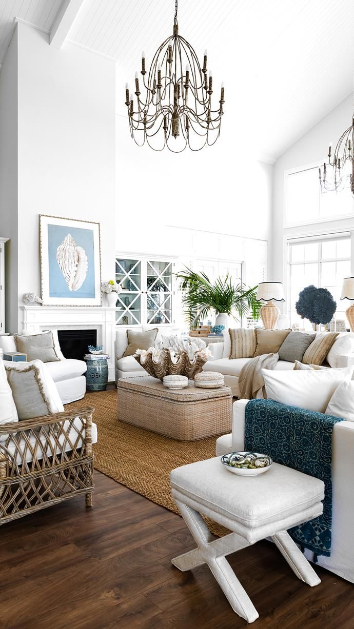 a living room filled with furniture and a chandelier hanging from the ceiling above