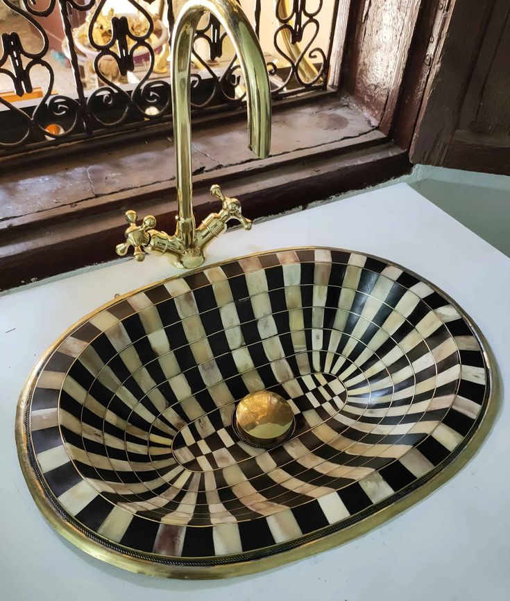 a black and white sink sitting on top of a counter next to a metal faucet