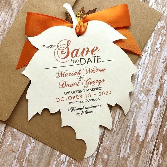 an orange and white wedding save the date card with a bow on top of it