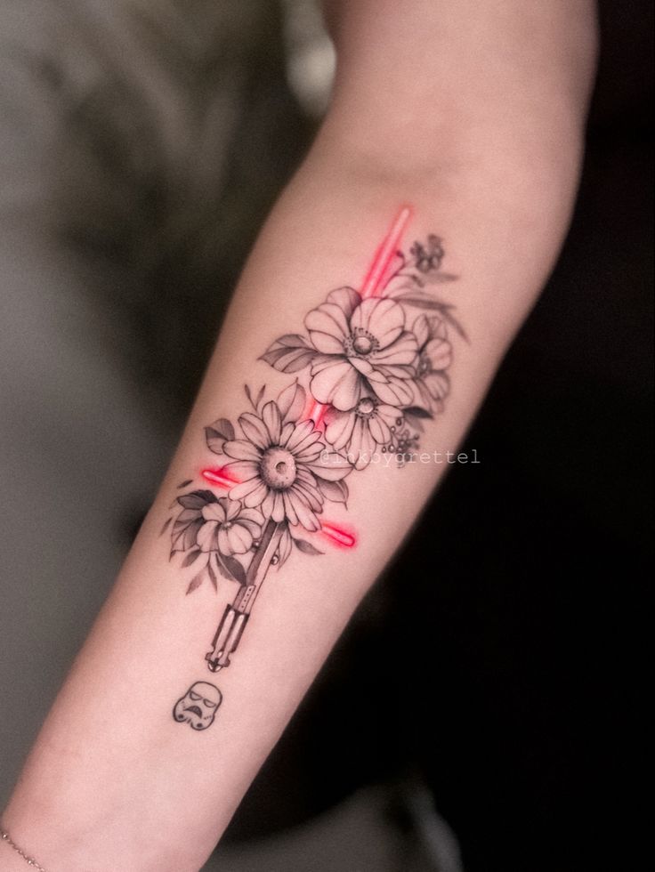 a woman's arm with flowers and a cross tattoo on the left side of her arm