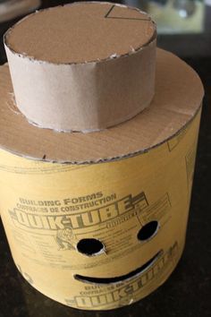 an open cardboard box sitting on top of a counter next to a roll of toilet paper