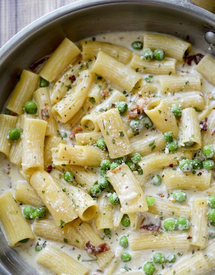 a pan filled with pasta and peas on top of a table