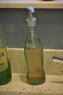 a bottle with liquid in it next to a soap dispenser on a counter