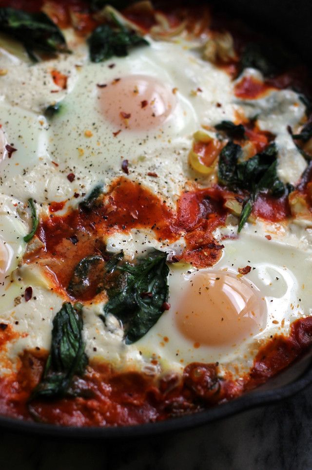 an egg and spinach pizza in a skillet